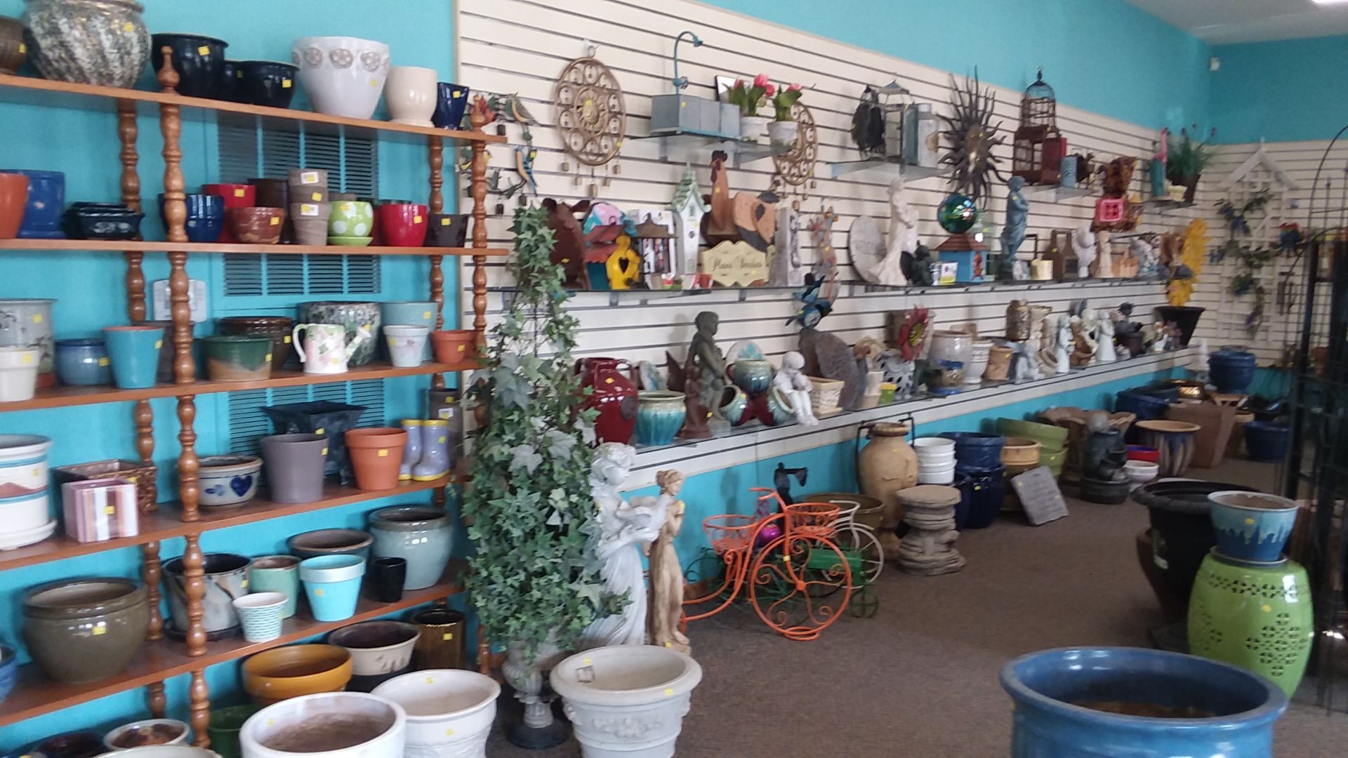 A display of lawn and garden supplies including large planter pots and decor.